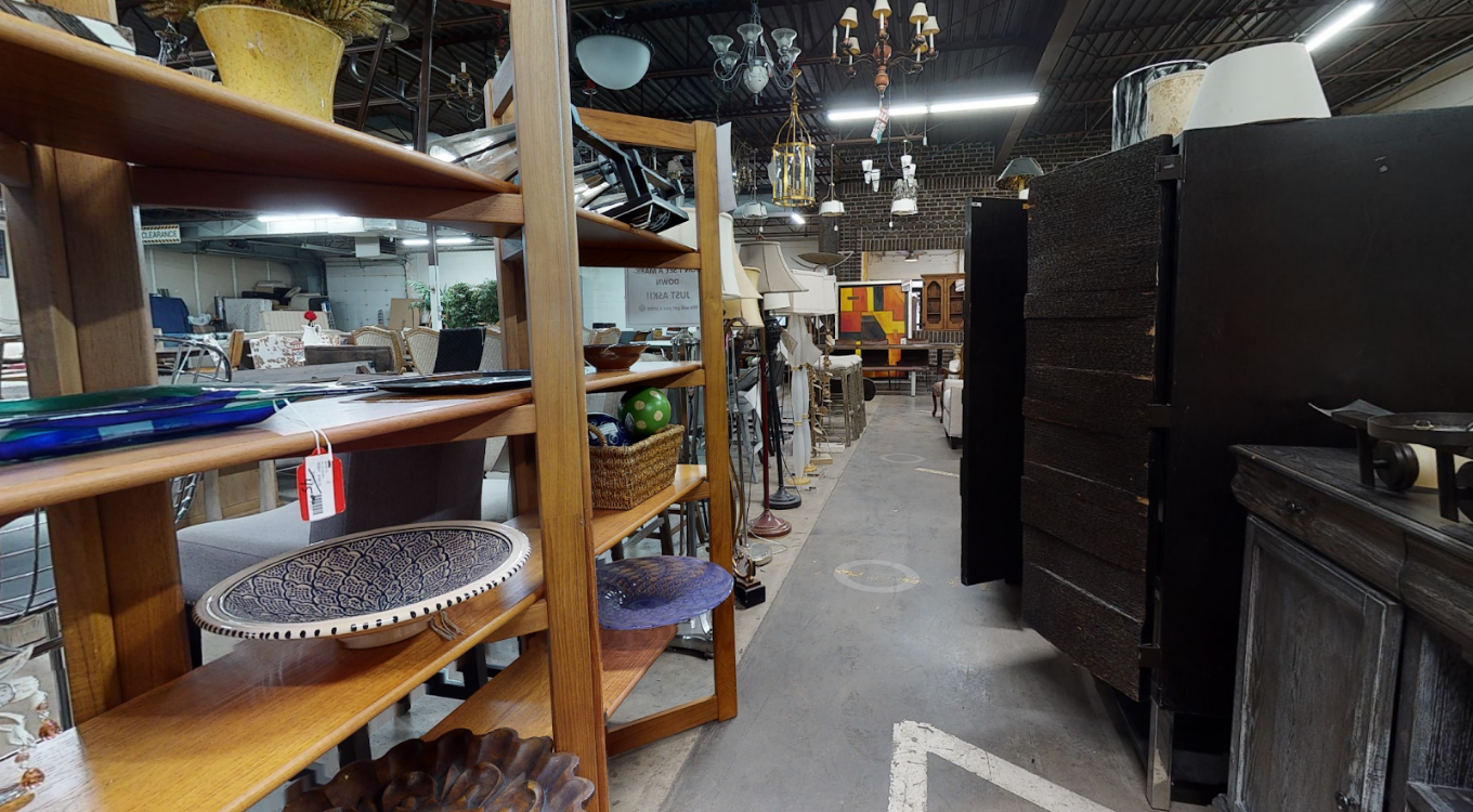 Teak shelving with pottery and lighting in a back aisle at Unique Furniture Warehouse, Twin Cities furniture outlet